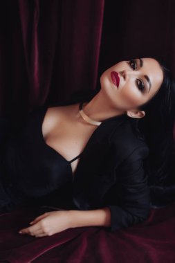 Siyah ceketli kadın stüdyoda poz veriyor.