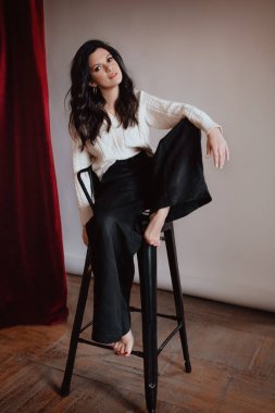 Stüdyoda beyaz kazaklı güzel bir kız.