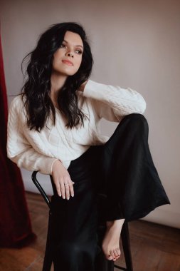 Siyah pantolonlu ve beyaz kazaklı güzel kız.