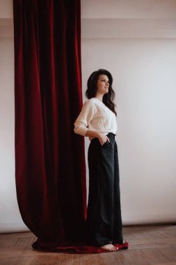 Beyaz kazaklı kadın stüdyoda poz veriyor.