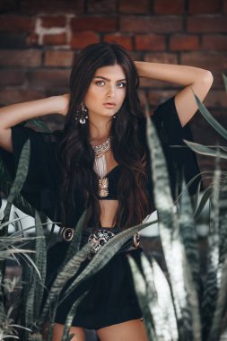 Tropikal bitkilerle güzel bir genç kızın portresi. Doğal kadın güzelliği