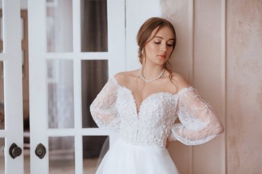 Enfes bir iç güzellikte, beyaz elbiseli, açık renk makyajlı güzel bir gelin. 