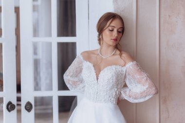 Enfes bir iç güzellikte, beyaz elbiseli, açık renk makyajlı güzel bir gelin. 