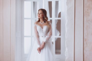 Enfes bir iç güzellikte, beyaz elbiseli, açık renk makyajlı güzel bir gelin. 