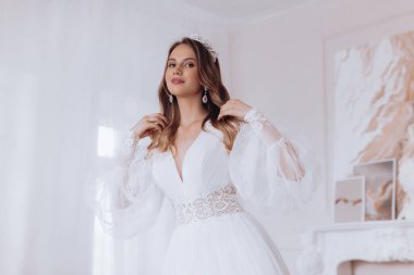 Enfes bir iç güzellikte, beyaz elbiseli, açık renk makyajlı güzel bir gelin. 