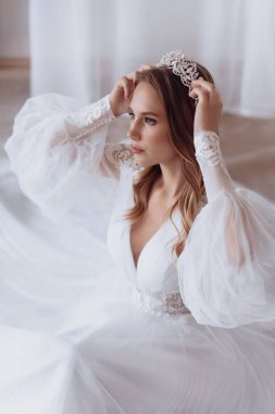 Enfes bir iç güzellikte, beyaz elbiseli, açık renk makyajlı güzel bir gelin. 