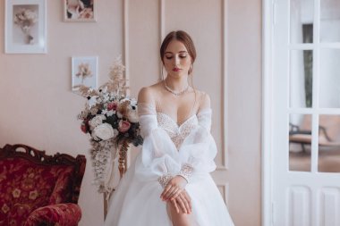 Zarif bir iç güzellikte beyaz elbiseli, açık renk makyajlı güzel bir gelin. 