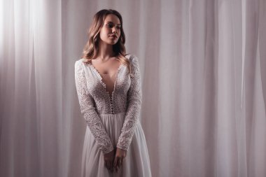 Enfes bir iç güzellikte, beyaz elbiseli, açık renk makyajlı güzel bir gelin. 