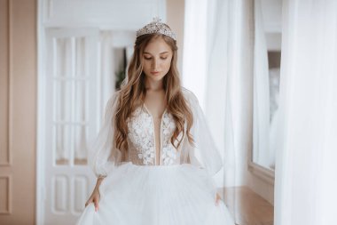 Enfes bir iç güzellikte, beyaz elbiseli, açık renk makyajlı güzel bir gelin. 