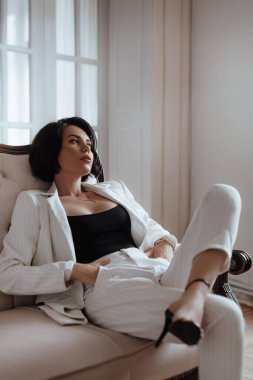 Zarif beyaz takım elbiseli muhteşem bir kadın. Doğal renkler. Doğal kadın güzelliği.