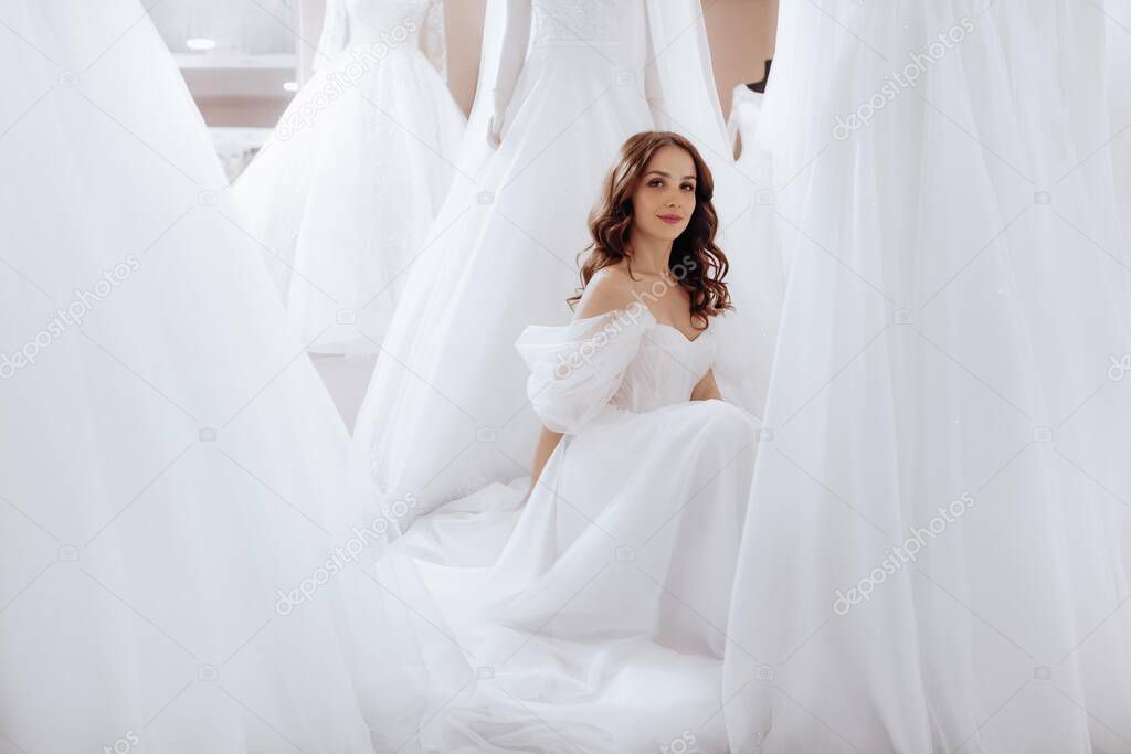 Beautiful brunette bride with light make-up in white dress  in an exquisite interior. Best day of life.