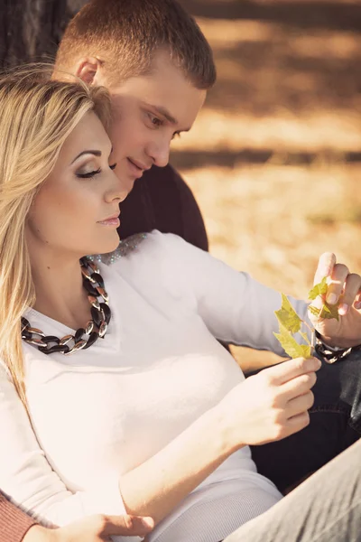 Couple sitting on park lawn — Stock Photo, Image