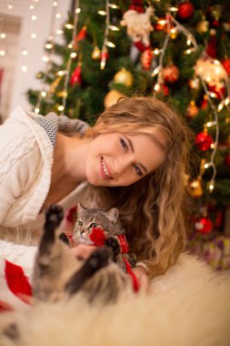 Kız yakınındaki bir kedi ile yeni yıl ağacı