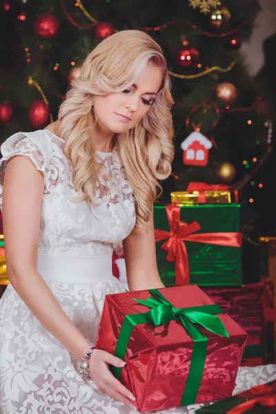 Mulher perto de uma árvore de Natal com presentes — Fotografia de Stock