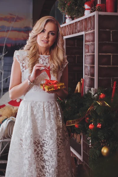 Mulher perto de uma árvore de Natal com presente — Fotografia de Stock