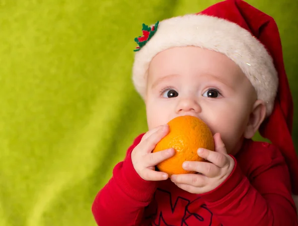 Little baby boy with a tangerine — Stock Photo, Image