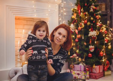 Noel ağacı yakınındaki kız bebek ile anne