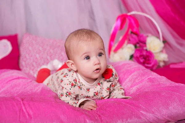Meisje van de baby liggend op roze kussen — Stockfoto