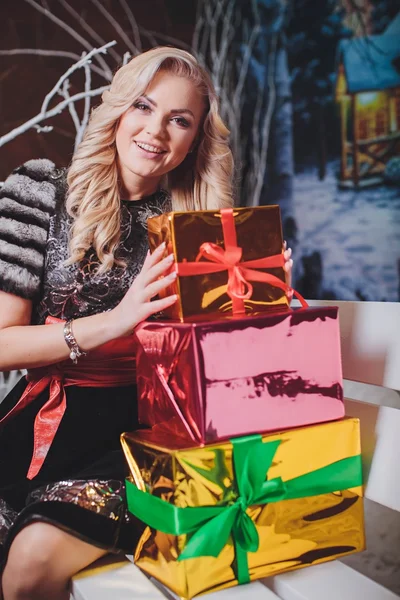 Woman sits on a bench with gifts — Stock Photo, Image