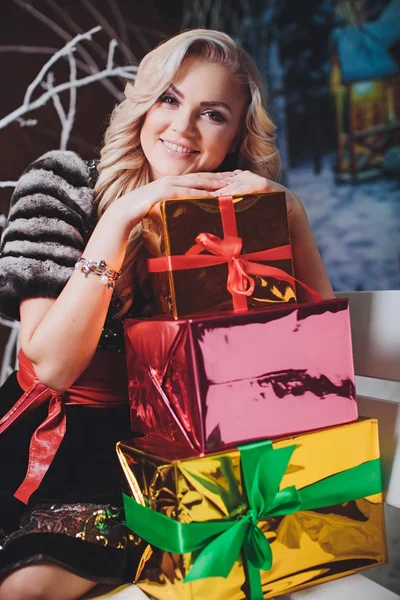 Mulher senta-se em um banco com presentes — Fotografia de Stock