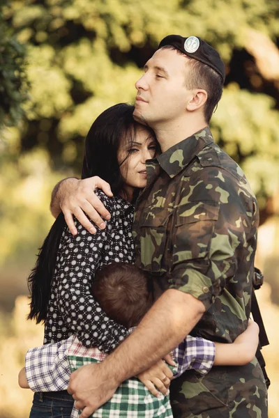Жена и сын обнимают солдата — стоковое фото
