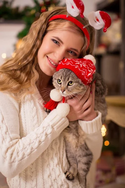 Girl with a cat in the cap of Santa — Stock Photo, Image