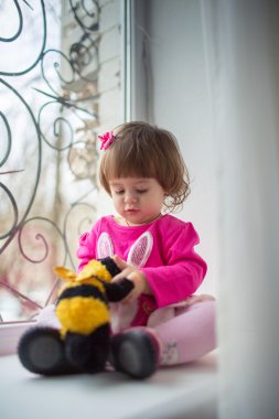 Little girl on a window sill clipart