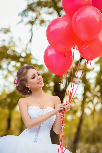 Bella sposa in posa con palloncini rosa — Foto Stock