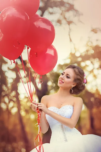 Bella sposa in posa con palloncini rosa — Foto Stock