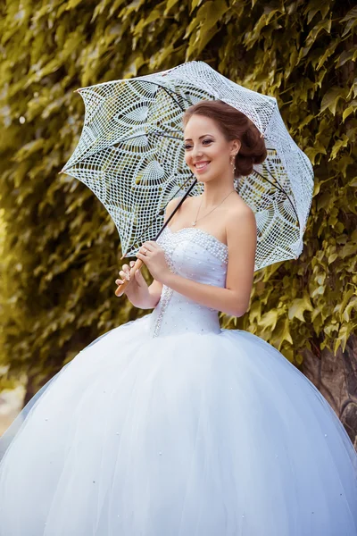 Beautiful bride with umbrella — Stock Photo, Image