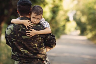 Boy and soldier in a military uniform clipart