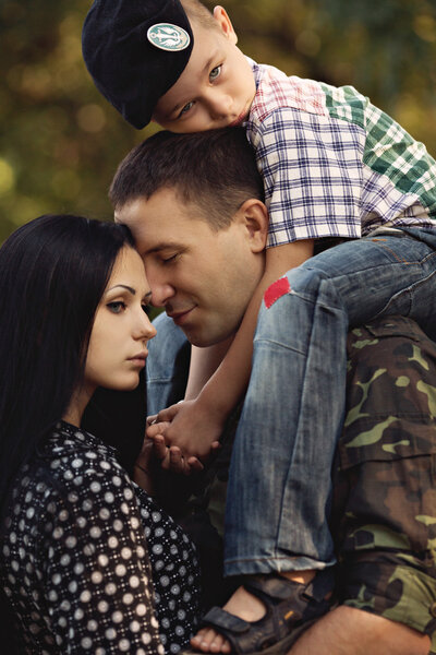 Жена и сын обнимают солдата
