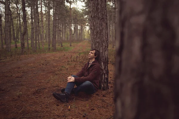 Человек, сидящий на лужайке — стоковое фото
