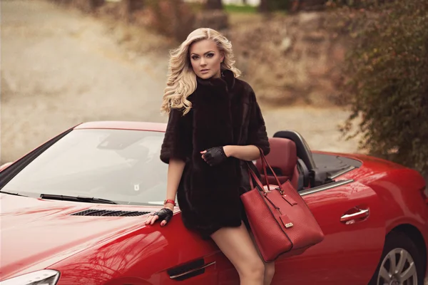 Kırmızı arabanın yakınında duran kadın — Stok fotoğraf