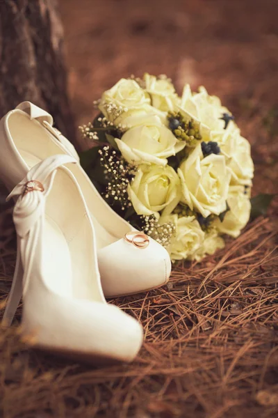 Chaussures de mariage femme avec un bouquet — Photo