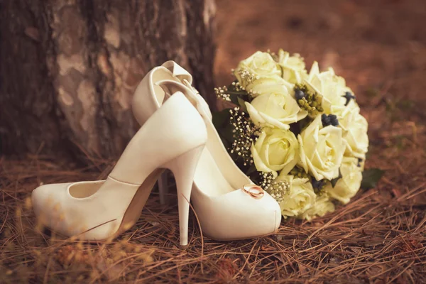 Chaussures de mariage femme avec un bouquet — Photo