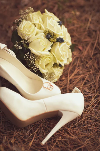 Female wedding shoes with a bouquet — Stock Photo, Image