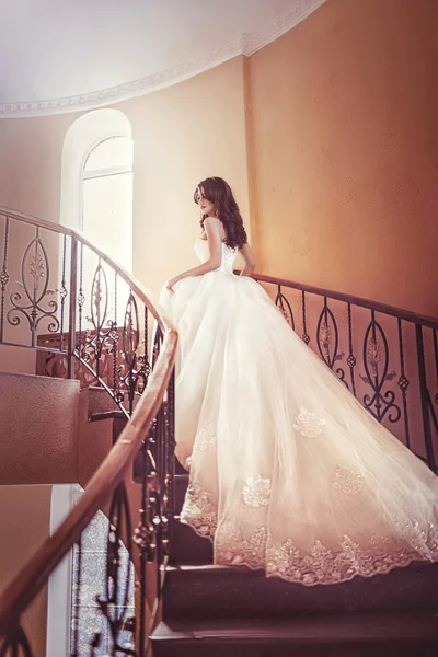 Невеста стоит на лестнице в белом платье — стоковое фото