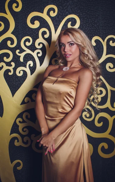 Красива жінка в золотій сукні — стокове фото