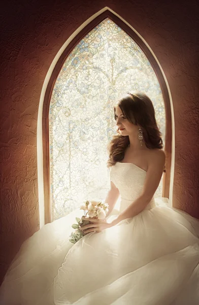 Bella sposa seduta vicino a una finestra — Foto Stock