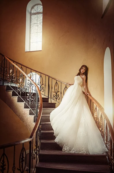 Braut steht im weißen Kleid auf der Treppe — Stockfoto