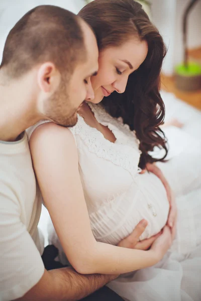 Mujer embarazada y su marido en el dormitorio — Foto de Stock