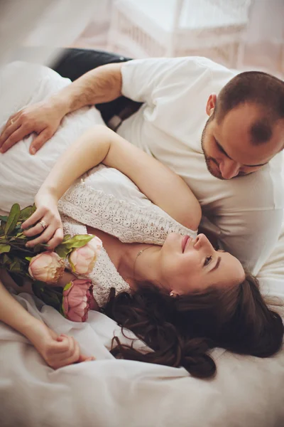 Zwangere vrouw en haar echtgenoot in de slaapkamer — Stockfoto