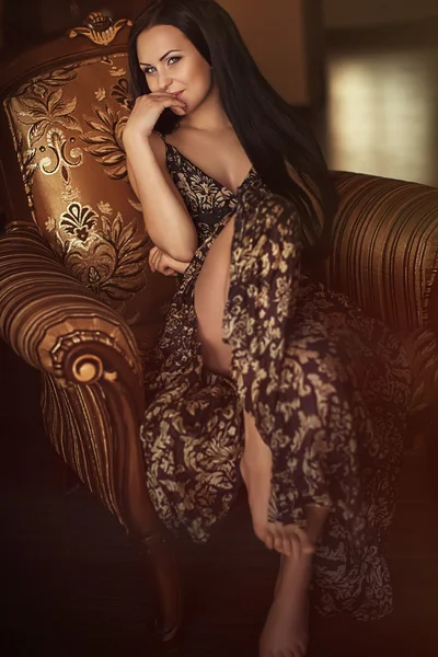Beautiful woman is in an arm-chair — Stock Photo, Image