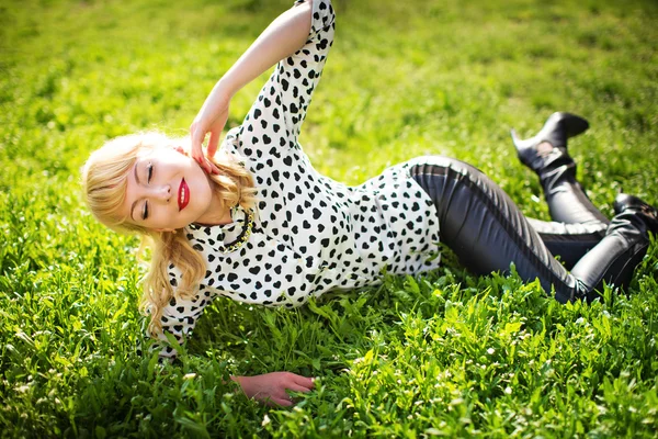 Frau liegt im Gras im Garten — Stockfoto