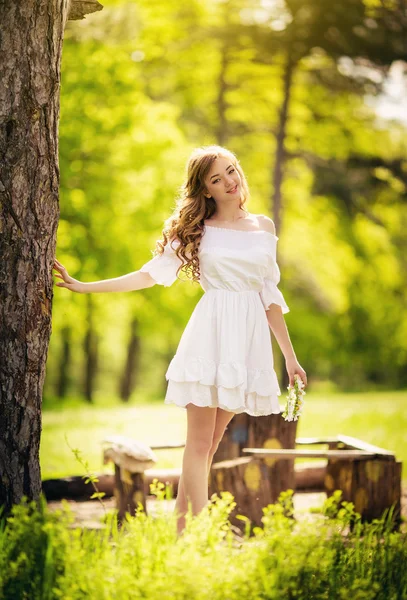 Kvinnan i vit klänning i vårträdgård — Stockfoto