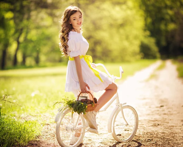 Жінка з велосипедом у весняному саду — стокове фото