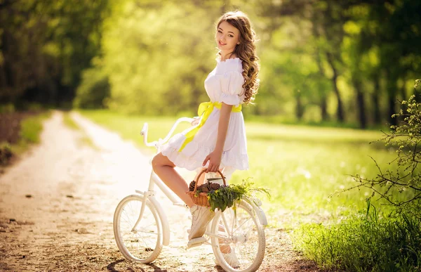 Femme avec vélo dans le jardin de printemps — Photo