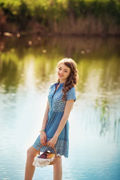 Jonge vrouw permanent in de buurt van de vijver — Stockfoto