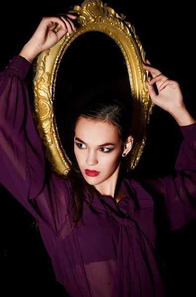 Modefrau posiert mit goldenem Rahmen — Stockfoto
